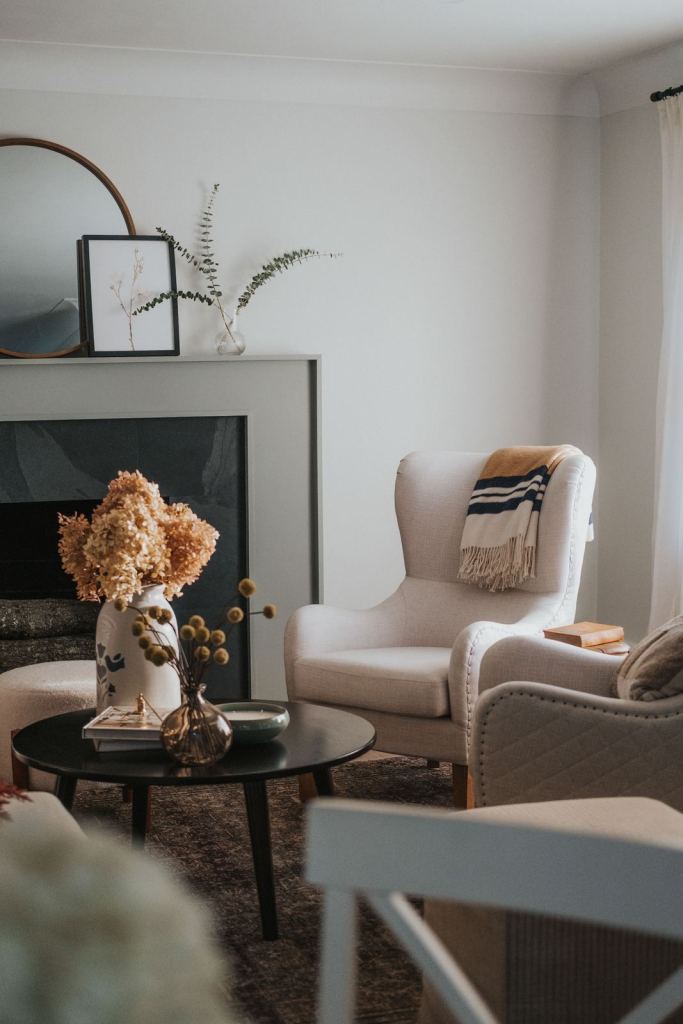 Living room with two cream wingback chairs by the fireplace